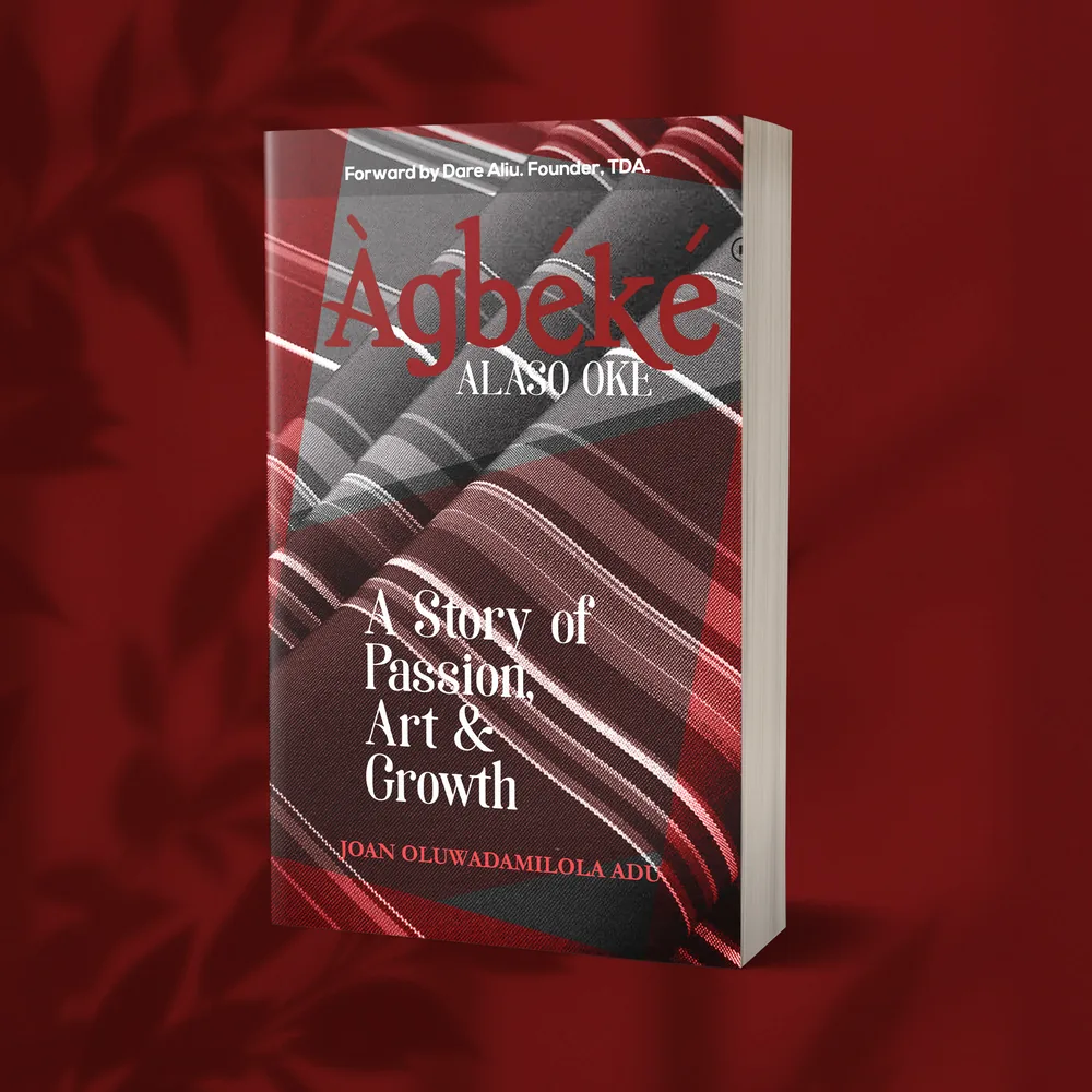 Three-dimensional burgundy mock-up of Joan Adu’s book cover.